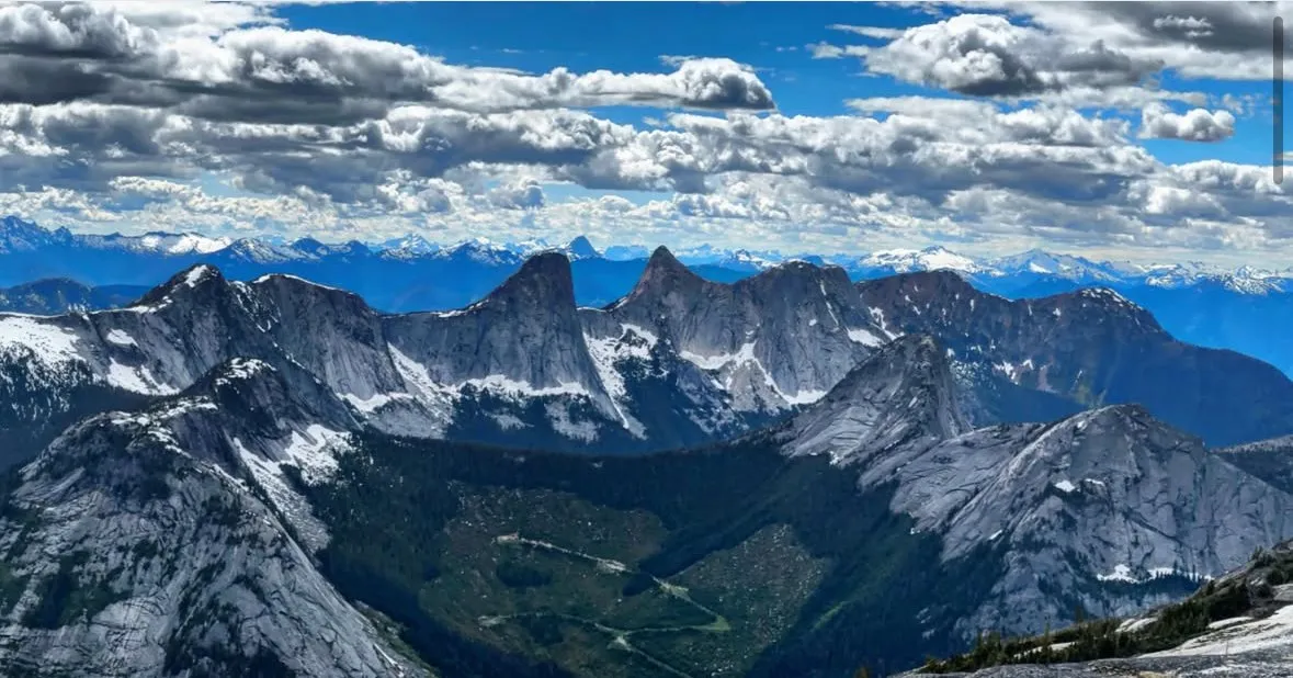 Snow-streaked granite peaks under a broken sky from Alpaca Peak