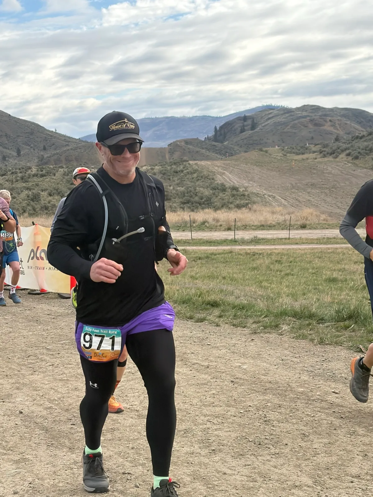 Trevor mid-race at a Dirty Feet trail race, dry grassland hills behind