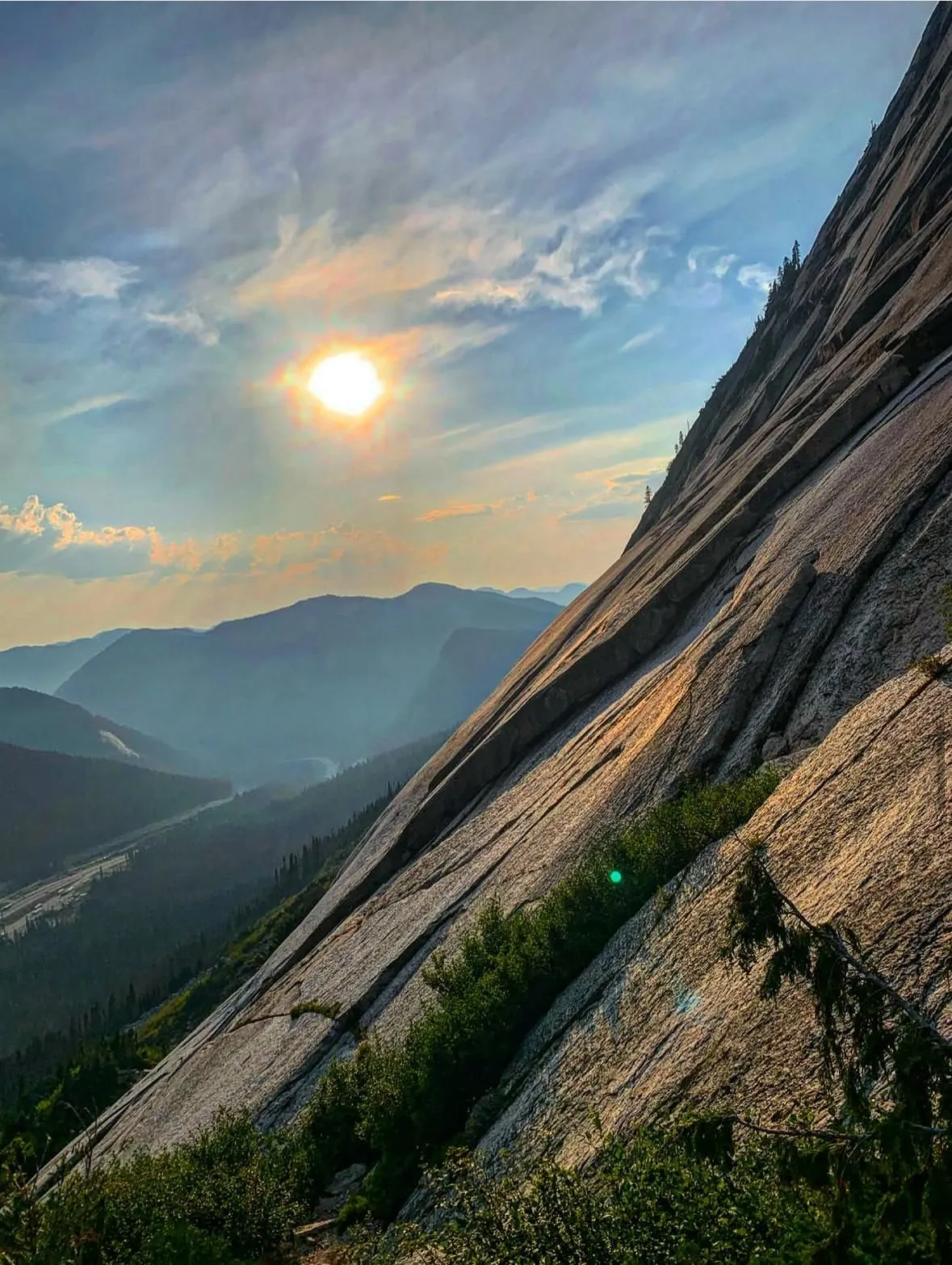 Evening sun over a granite slab with valley haze below
