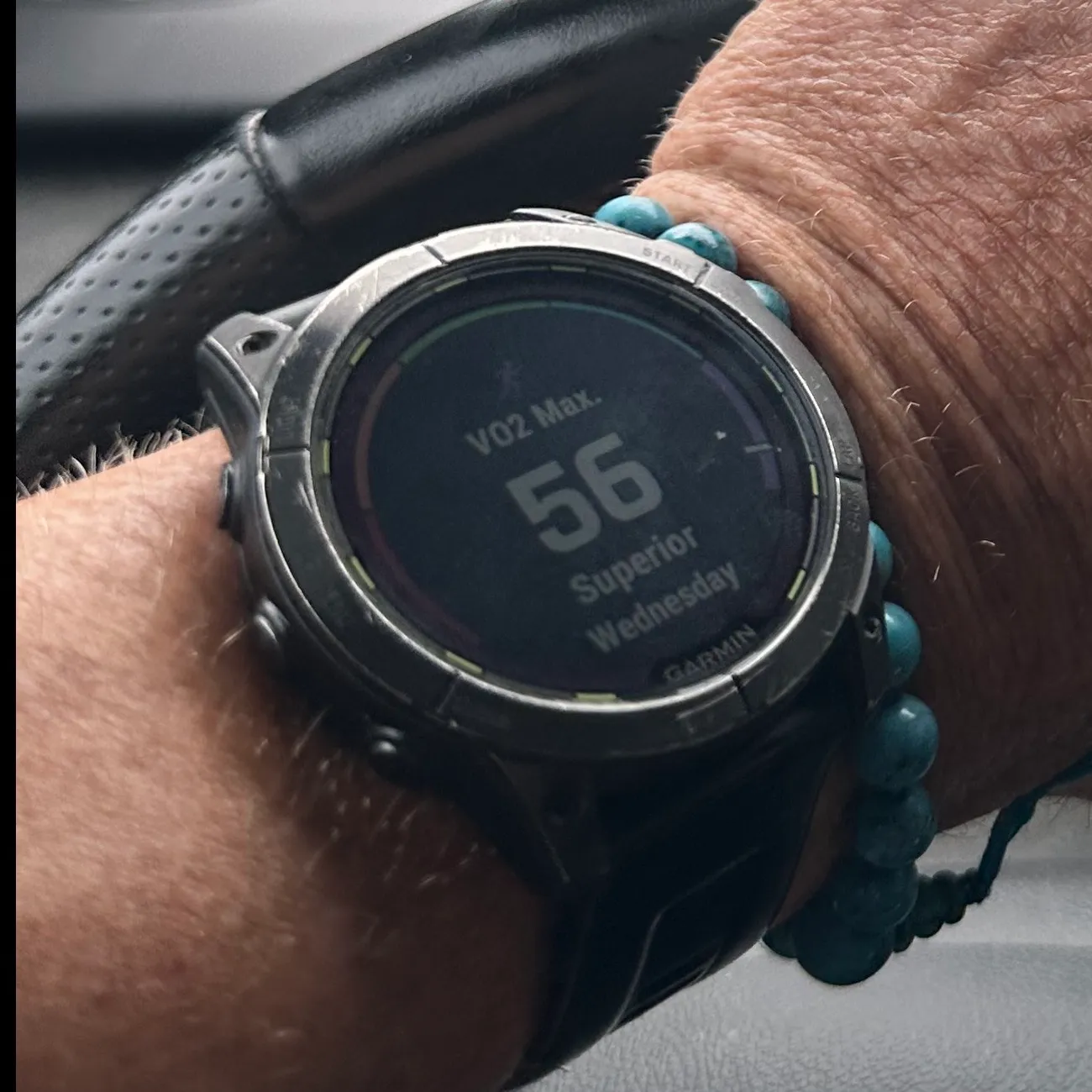 Trevor’s Garmin on his wrist, the screen reading VO2 Max 56, Superior