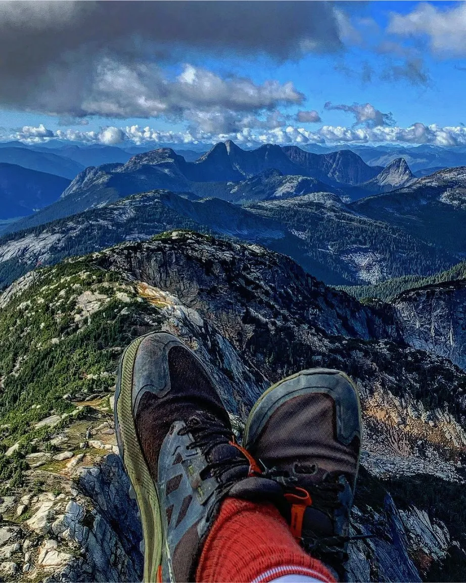 Boots up on a summit, ridgelines running to the horizon